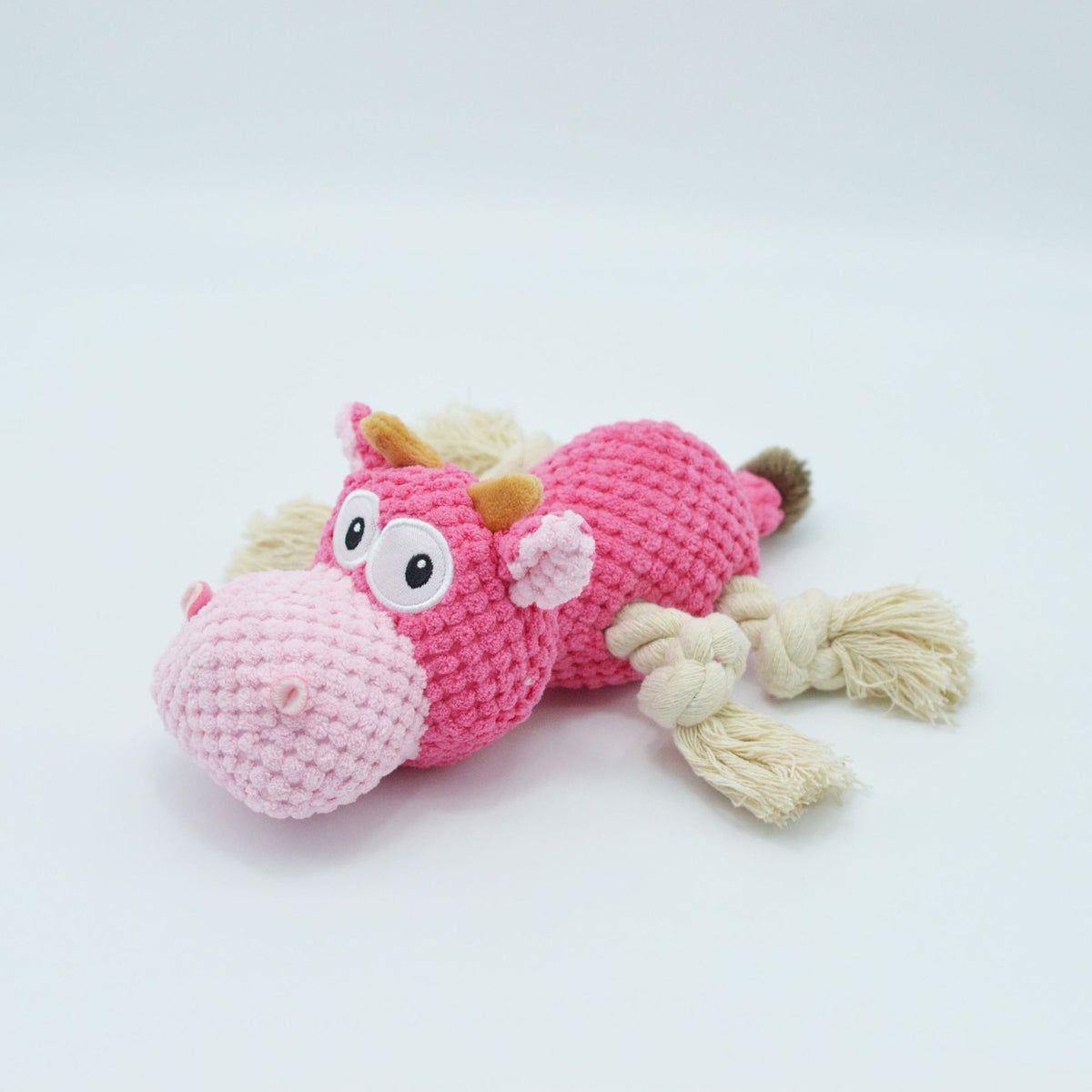 Dog chewing on plush squeaky toy